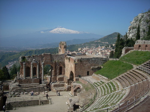 Άποψη του αρχαίου θεάτρου. Στο βάθος διακρίνονται οι κορυφές της Αίτνας. πηγή: Wikipedia